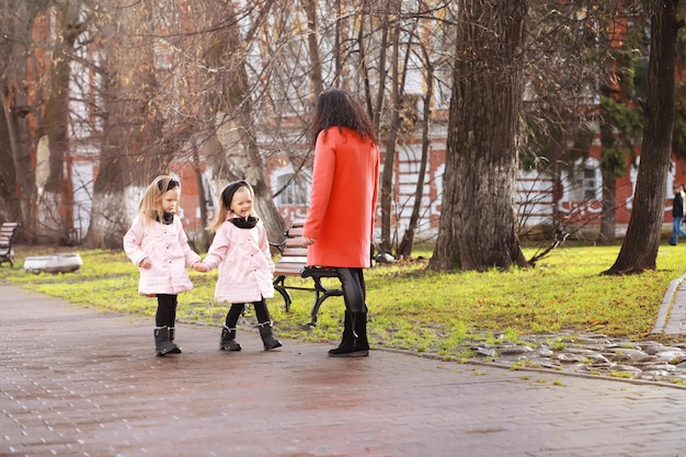 Young family on a walk in the autumn park on a sunny day. Happiness to be together.