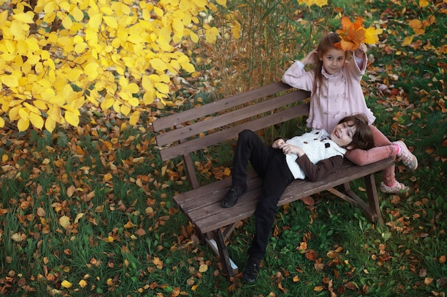 Young family on a walk in the autumn park on a sunny day. Happiness to be together.