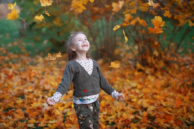 Young family on a walk in the autumn park on a sunny day. Happiness to be together.