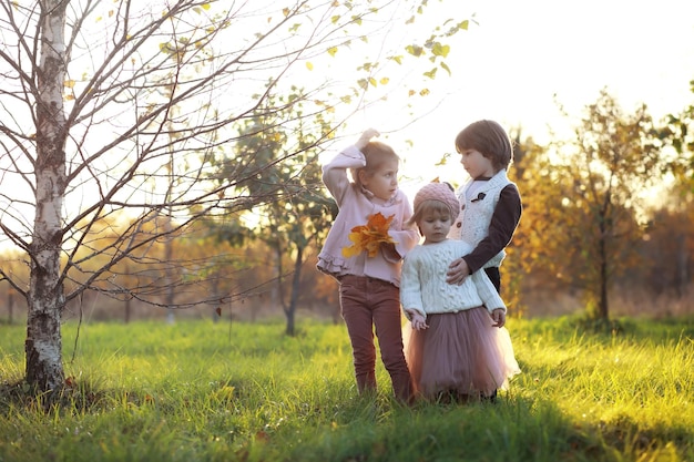 Young family on a walk in the autumn park on a sunny day. Happiness to be together.