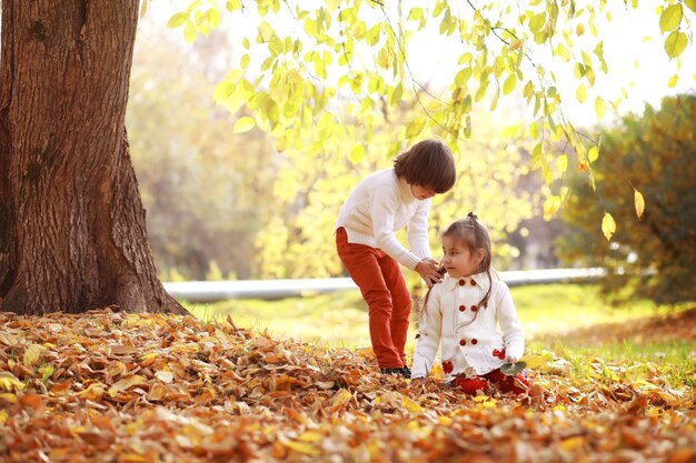 Young family on a walk in the autumn park on a sunny day. Happiness to be together.