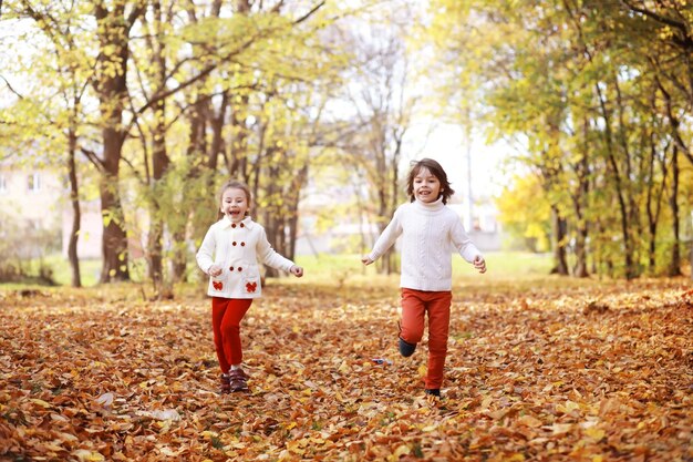 Young family on a walk in the autumn park on a sunny day Happiness to be together