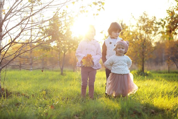 Giovane famiglia in una passeggiata nel parco autunnale in una giornata di sole felicità di stare insieme