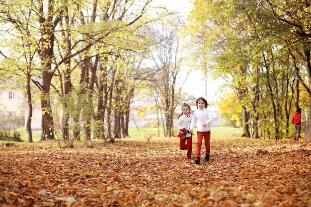 Young family on a walk in the autumn park on a sunny day Happiness to be together