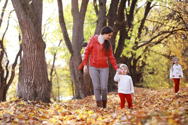 Young family on a walk in the autumn park on a sunny day Happiness to be together