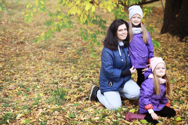 晴れた日に秋の公園を散歩する若い家族一緒に幸せ