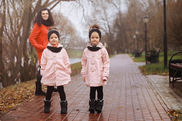 Giovane famiglia in una passeggiata nel parco autunnale in una giornata di sole felicità di stare insieme