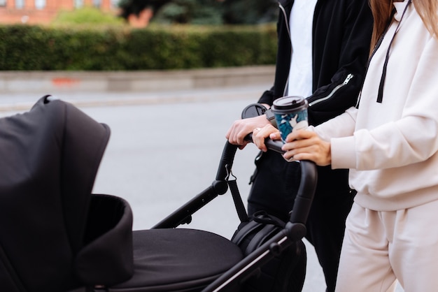 A young family with a baby stroller walks around the city in the summer