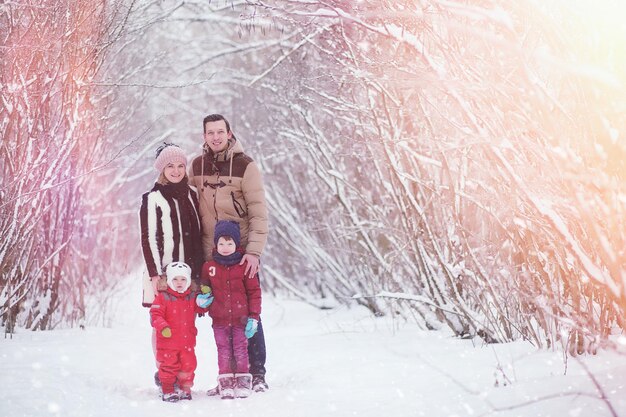 Young family with children are walking in the winter park Winter walk of parents with children Walking on a holiday weekend in the winter