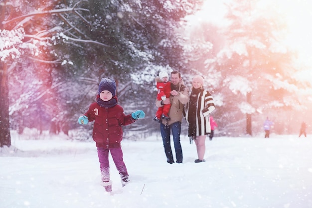 Young family with children are walking in the winter park Winter walk of parents with children Walking on a holiday weekend in the winter