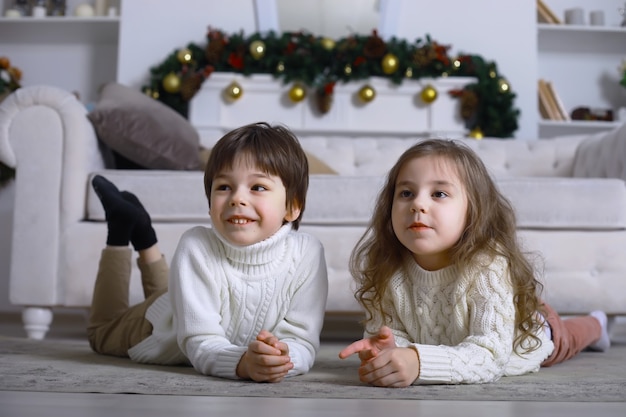 子供連れの若い家族が休日の家を飾ります。大晦日。新年を待っています。