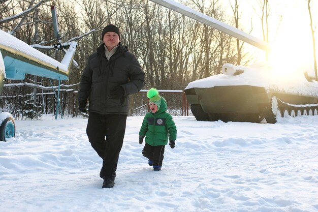 冬に公園を散歩している子供を持つ若い家族