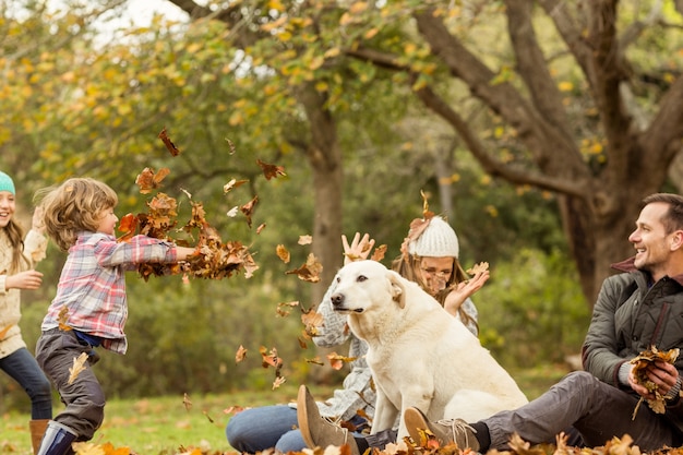 Young family with a dog in leaves