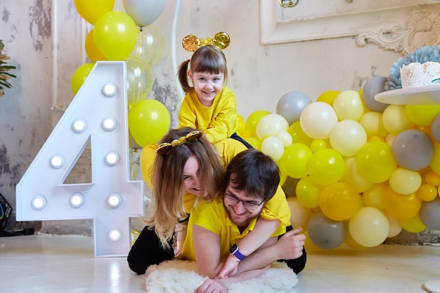 Young family with a girl having fun at the celebration of their daughter's fourth birthday.