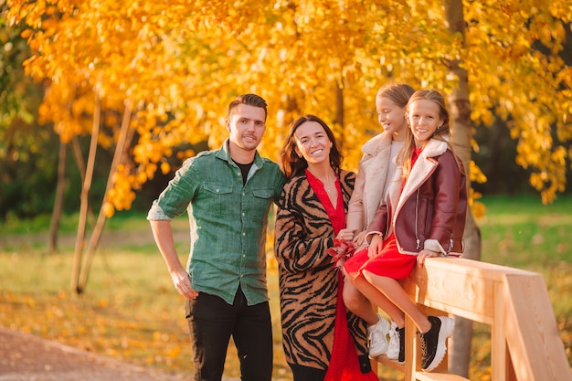 Young family with little kids in autumn park on sunny day. Family autumn portrait