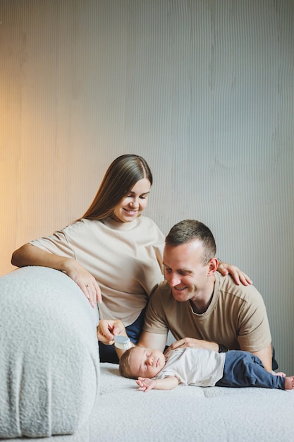 A young family with a newborn baby Happy mother and father kissing their child Parents and a smiling child in their arms