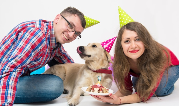 Young family with their dog golden retriever celebrate one year birthday.