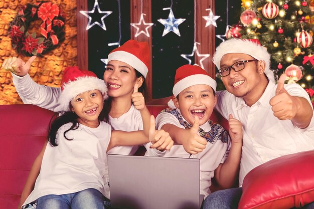 Young family with thumb up on christmas day