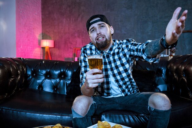 Young fanatic man watching football game on television nervous a