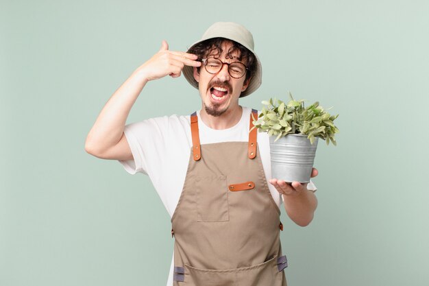 Photo young farmer man looking unhappy and stressed, suicide gesture making gun sign