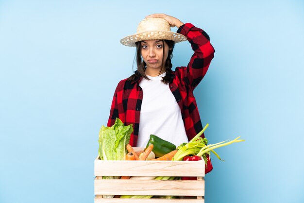 Young farmer Woman holding fresh vegetables in a wooden basket with an expression of frustration and not understanding