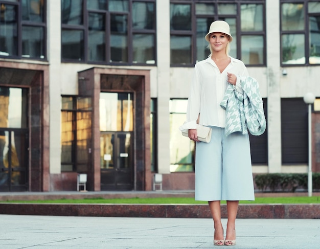 Young fashion blond woman walking on the street