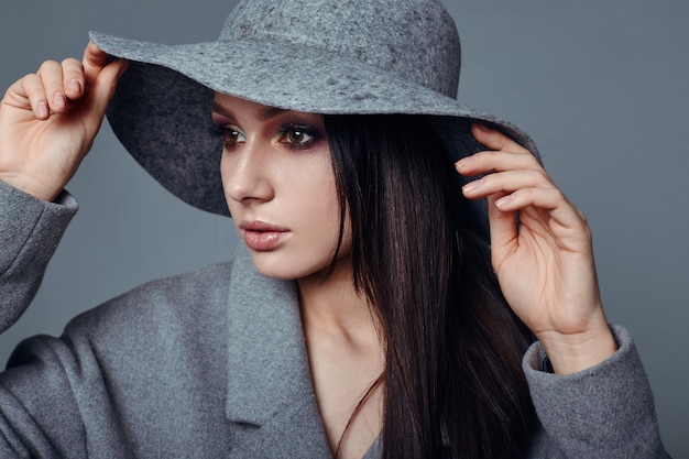 Young fashion brunette woman beauty in gray coat and hat