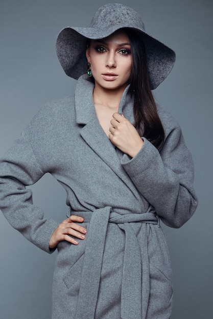 Young fashion brunette woman beauty in gray coat and hat