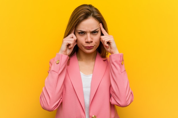 Young fashion business woman focused on a task, keeping her forefingers pointing head.