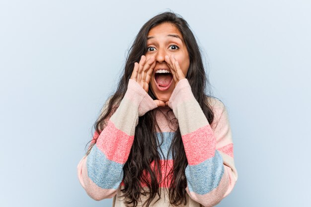 Young fashion indian woman shouting excited to front.