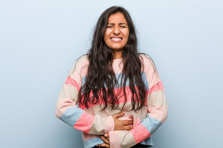 Photo young fashion indian woman sick, suffering from stomachache, painful disease concept.
