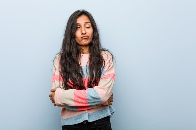 Young fashion indian woman unhappy looking in camera with sarcastic expression