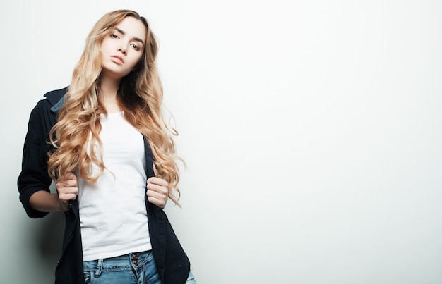 Young fashion model posing in studio, white background