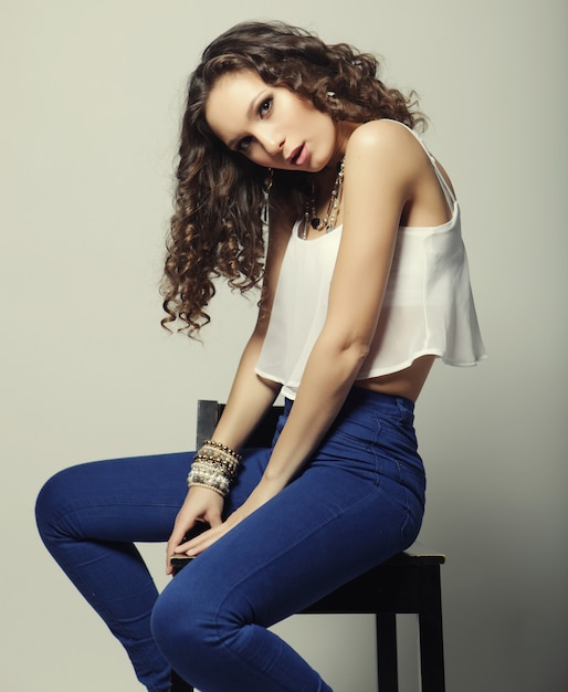 Young fashion model sitting on chair