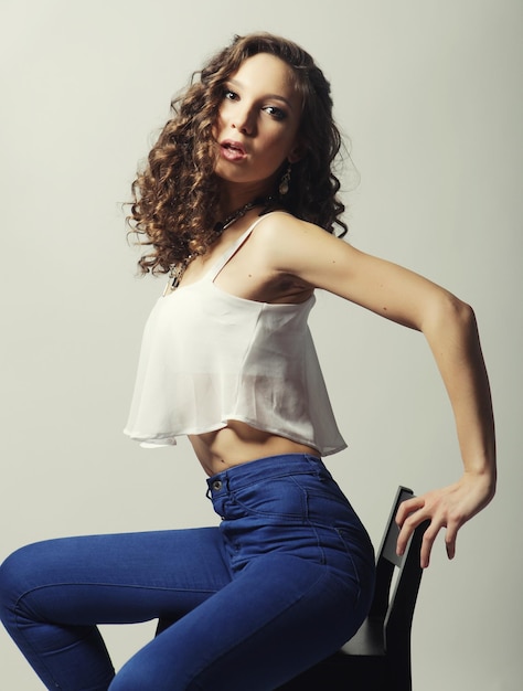 Young fashion model sitting on chair