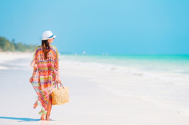 Young fashion woman in a beautiful dress on the beach