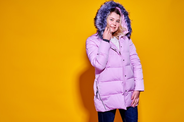 Young fashion woman in short violet down jacket