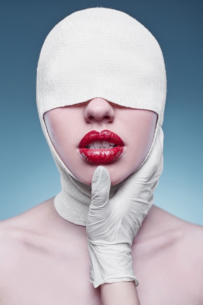 Young fashion woman with bandaged head and nurse hands