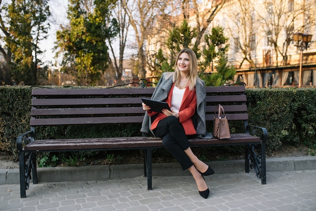 Young fashionable businesswoman on a bench