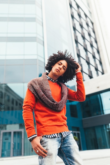 Young fashionable dressed curly black African American with glasses walks through the streets