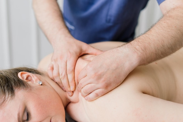 Young fat woman getting massage treatment in a day spa cabinet.