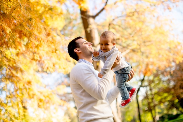 Young father and baby boy in autumn park