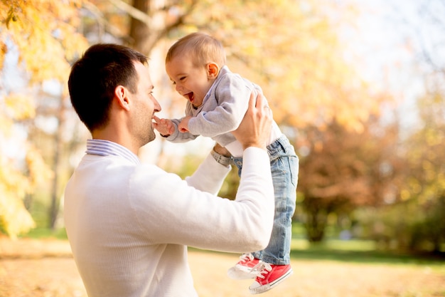 Young father and baby boy in autumn park