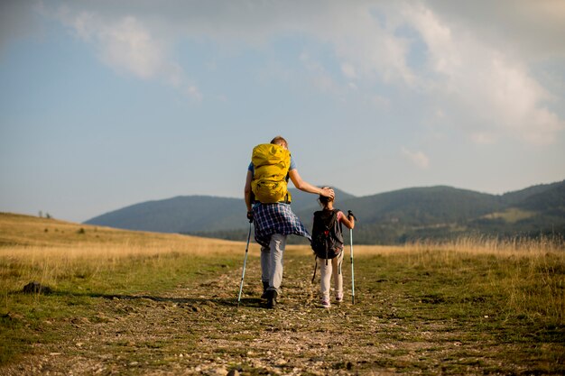 Young father and daughter enjoy hiking on a sunny day