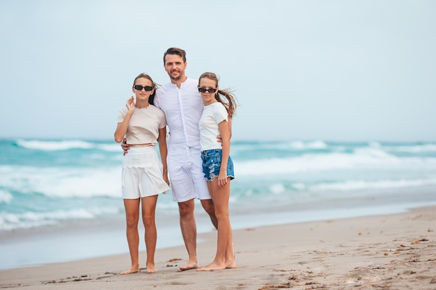 Young father and his adorable teen daughters on the beach Family vacation