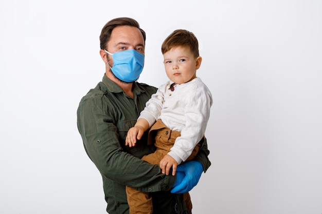 Young father and his toddler son wearing surgical masks