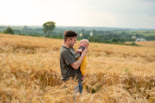 Young father holds his son in his arms