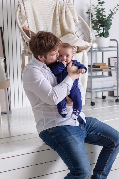 Young father kissing his little baby in the cheek in the studio