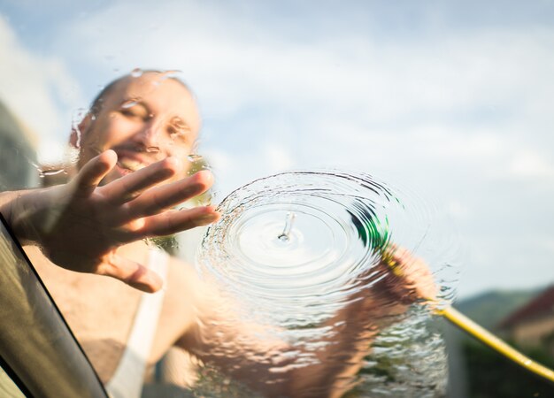 Young father and little sons washing car