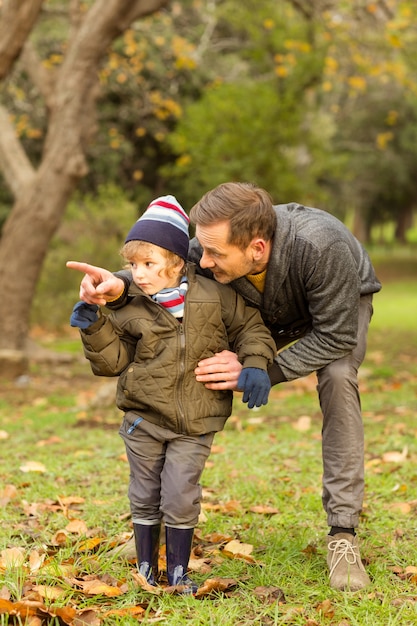 Young father showing something to his cute son